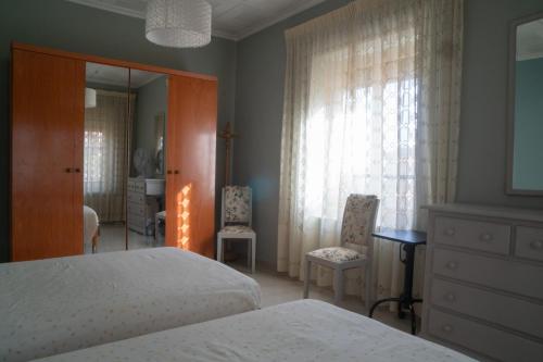 een slaapkamer met een bed, 2 stoelen en een spiegel bij Gran apartamento en el centro Villajoyosa - Vistas al mar, 5 dormitorios y enorme terraza in Villajoyosa