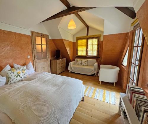 Un dormitorio con una gran cama blanca y una silla. en Petite Bellevue, en Baden-Baden