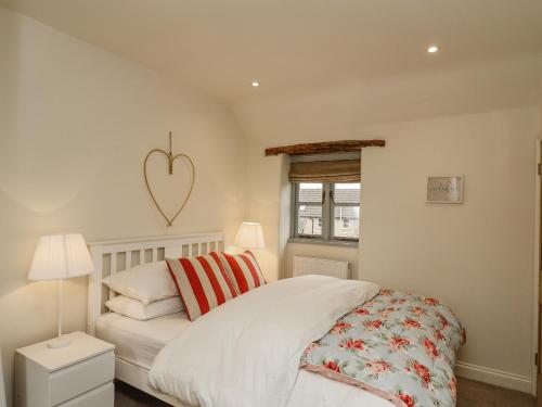 a bedroom with a bed with a heart on the wall at Pheasant Cottage in Oakham