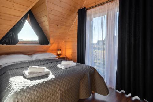 a bedroom with a bed and a large window at TATRAHOLIDAY- Domek na wierchu in Szaflary