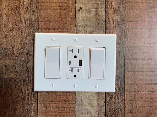 a white light switch on a wooden wall at The Residency Suites in Sugar Land
