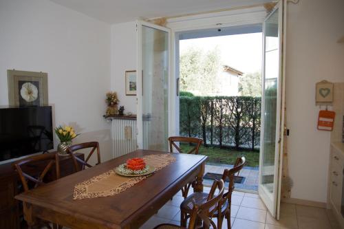 a dining room with a table and chairs and a sliding glass door at Appartamento con giardino e parcheggio privato in Bellagio