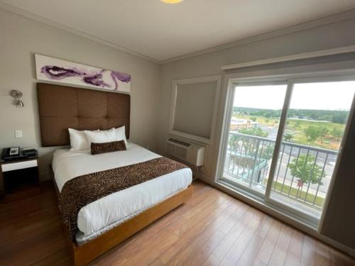 a bedroom with a bed and a large window at Baymont by Wyndham Fort McMurray in Fort McMurray