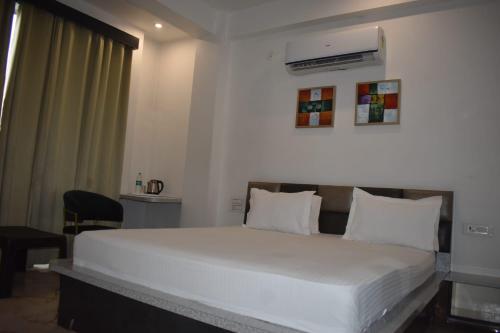 ein Schlafzimmer mit einem großen Bett mit weißer Bettwäsche in der Unterkunft Hotel celebration in Alwar