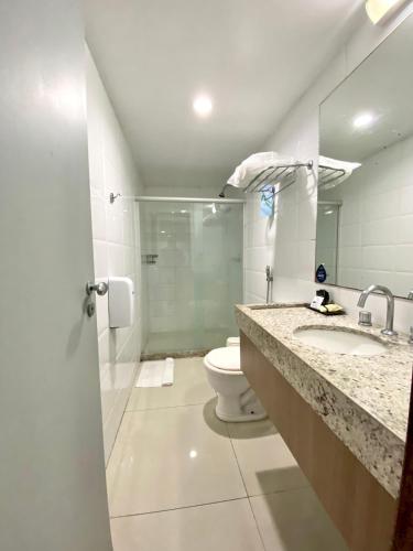 a bathroom with a toilet and a sink at Nobile Suítes Tambaú in João Pessoa
