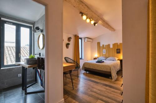 une chambre avec un lit et un bureau dans une pièce dans l'établissement Melina - jacuzzi - maison avec cour climatisée proche cité médiéval, à Carcassonne