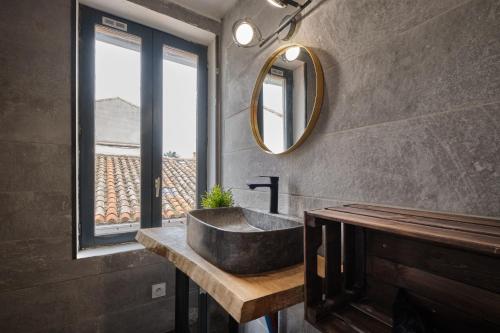 une salle de bain avec un lavabo et un miroir dans l'établissement Melina - jacuzzi - maison avec cour climatisée proche cité médiéval, à Carcassonne