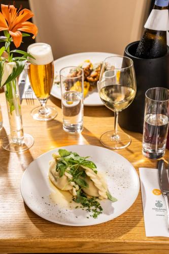 a table with two plates of food and glasses of wine at Wellness Landhaus Parth in Ossiach