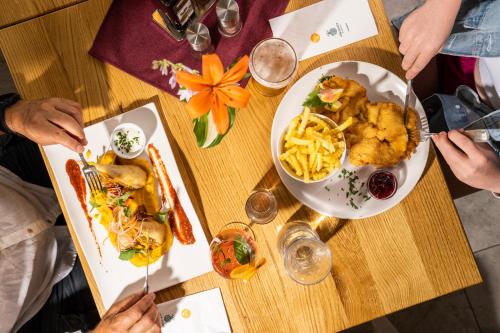 a group of people sitting at a table with plates of food at Wellness Landhaus Parth in Ossiach