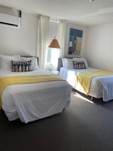 two beds in a hotel room with two bedsskirts at Paradise Inn On the Beach in Port Elgin