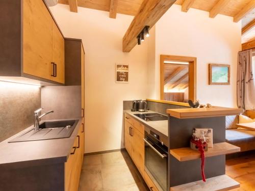 a kitchen with wooden cabinets and a sink at Apartments Heissangerer in Tulfes