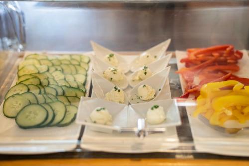 a plate of food with cucumbers and other vegetables at Wellness Landhaus Parth in Ossiach