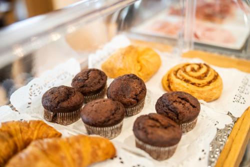 a tray of muffins and pastries in a display case at Wellness Landhaus Parth in Ossiach