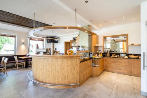a kitchen with a bar and a dining room at Wellness Landhaus Parth in Ossiach