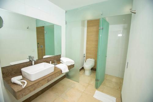 a bathroom with a sink and a toilet at Hotel Barranquilla Plaza in Barranquilla