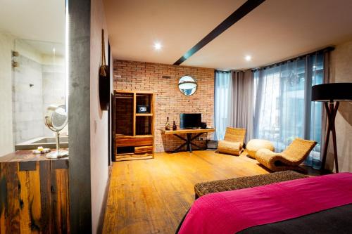 a bedroom with a bed and a desk in a room at Múbú Hotel Boutique in Valle de Bravo