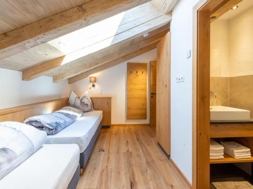 two beds in a room with a sink and a mirror at Apartments Heissangerer in Tulfes