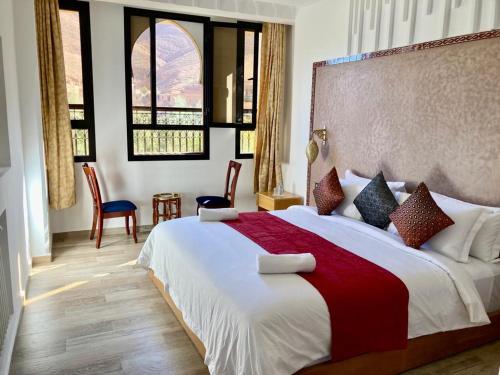 a bedroom with a large bed with a red blanket at Riad Dades Paradise in Boumalne Dades