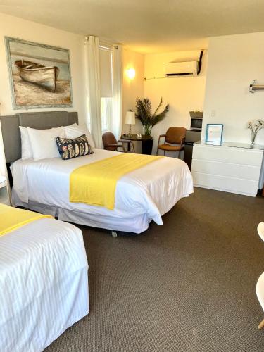 a hotel room with two beds and a desk at Paradise Inn On the Beach in Port Elgin