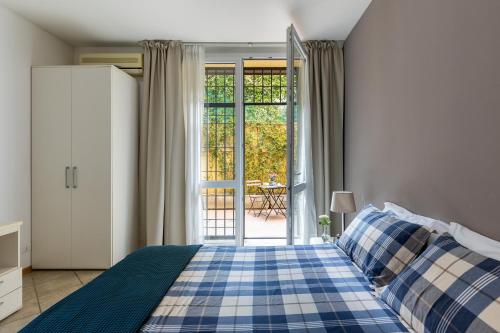 a bedroom with a blue and white bed and a patio at Portobello Apartments in Bologna