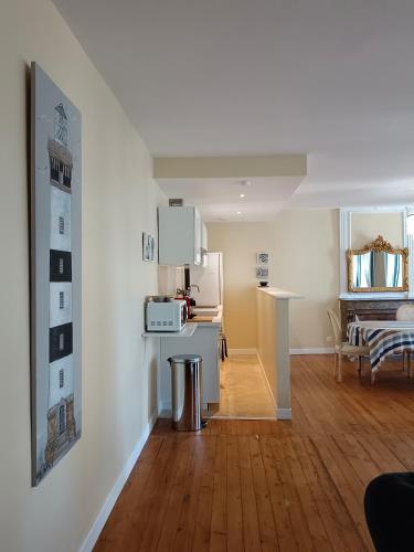 Il comprend un salon doté de murs blancs et de parquet. dans l'établissement Duc de Bretagne Luxury Apparthotel, à Morlaix