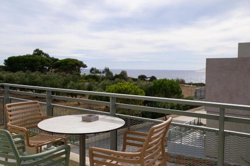 a balcony with a table and chairs and the ocean at Callisto Seaside Homes & Suites in Marathopolis