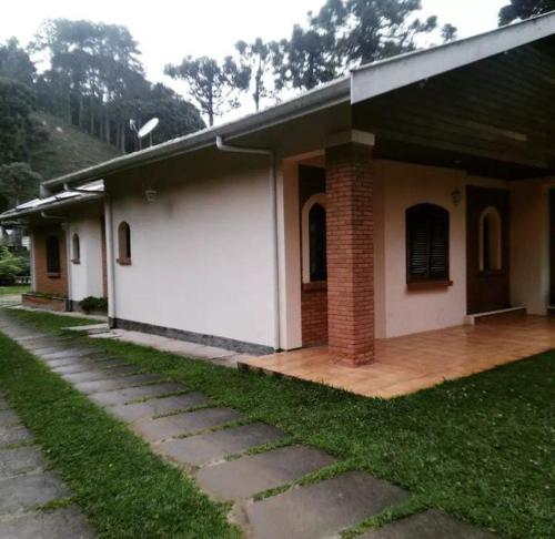 a small white house with a brick at Pequeno Paraiso in Campos do Jordão