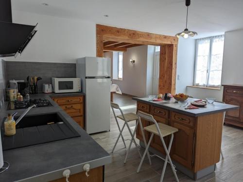 a kitchen with a refrigerator and a counter top at Maison lumineuse avec cour privative, proche sites culturels, tout confort, équipé bébé, wifi inclus - FR-1-653-98 in Puyréaux