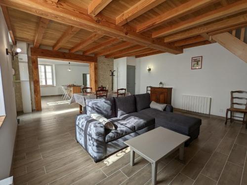 een woonkamer met een bank en een tafel bij Gîte Puyréaux, 3 pièces, 4 personnes - FR-1-653-98 in Puyréaux