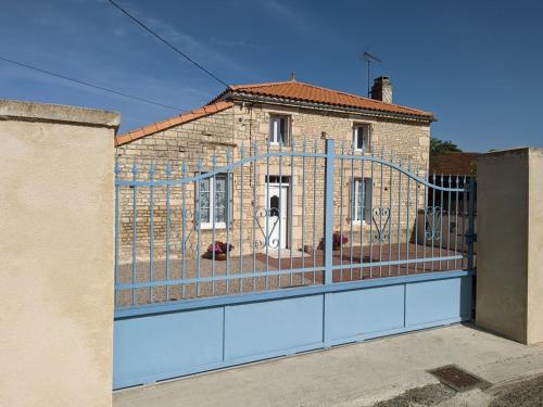 a fence in front of a brick building at Maison lumineuse avec cour privative, proche sites culturels, tout confort, équipé bébé, wifi inclus - FR-1-653-98 in Puyréaux