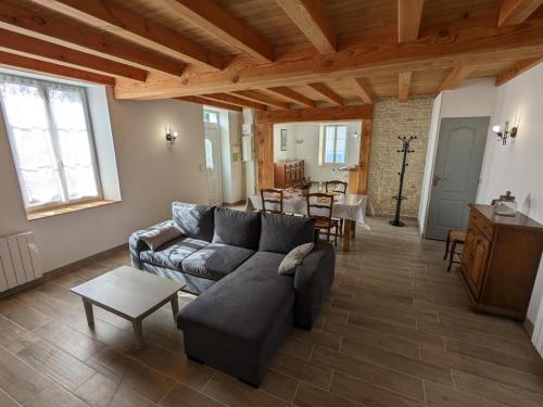 a living room with a couch and a table at Maison lumineuse avec cour privative, proche sites culturels, tout confort, équipé bébé, wifi inclus - FR-1-653-98 in Puyréaux