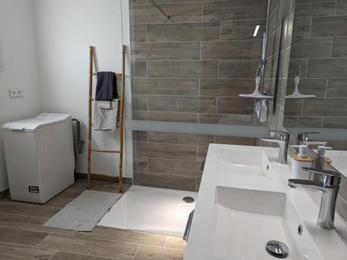 a bathroom with two sinks and a brick wall at Maison lumineuse avec cour privative, proche sites culturels, tout confort, équipé bébé, wifi inclus - FR-1-653-98 in Puyréaux