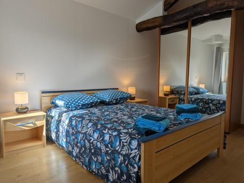 a bedroom with two beds with blue comforter and blue pillows at Maison lumineuse avec cour privative, proche sites culturels, tout confort, équipé bébé, wifi inclus - FR-1-653-98 in Puyréaux