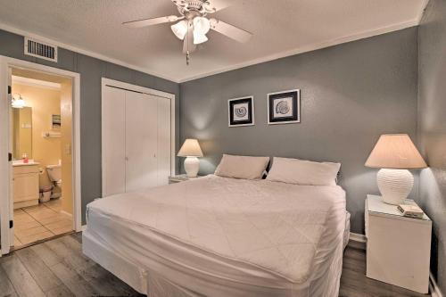 um quarto com uma cama e uma ventoinha de tecto em South Myrtle Condo with Balcony - Walk to the Beach! em Myrtle Beach