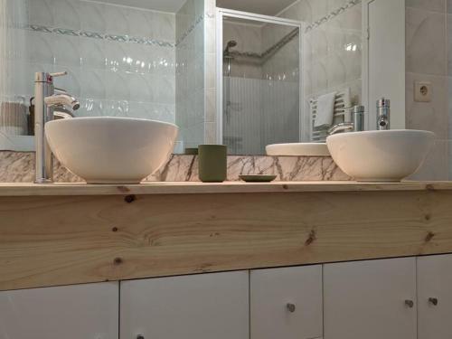 - une salle de bains avec deux lavabos sur un comptoir en bois dans l'établissement Gîte familial en pleine nature avec piscine chauffée et équipements bébé - FR-1-653-129, à Montmoreau