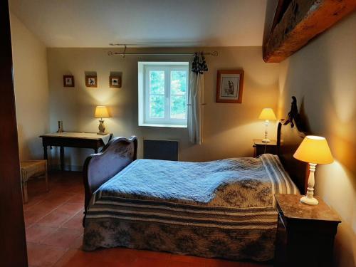 1 dormitorio con cama, escritorio y ventana en Gîte Vitrac-Saint-Vincent, 4 pièces, 6 personnes - FR-1-653-132, en Montembœuf