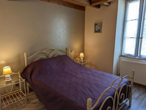 a bedroom with a bed with a purple blanket at Gîte de charme avec jardin, proche d'Aubeterre-sur-Dronne, pour 6 pers., cheminée, WIFI, équipements bébé - FR-1-653-116 in Bellon