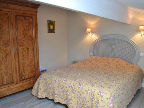 Schlafzimmer mit einem Bett und einem Holzschrank in der Unterkunft Gîte Saint-Sulpice-de-Cognac, 2 pièces, 2 personnes - FR-1-653-139 in Saint-Sulpice-de-Cognac