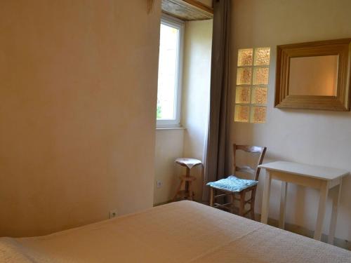 a bedroom with a bed and a desk and a window at Maison familiale avec grand jardin près du Périgord - 3 chambres, WIFI et vélos fournis - FR-1-653-171 in Combiers