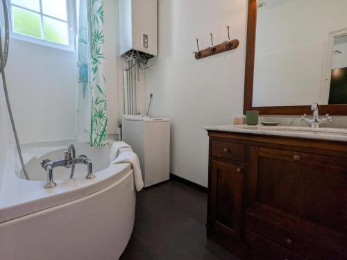 une salle de bain avec une baignoire et un lavabo dans l'établissement Gîte familial avec piscine chauffée, jardin privé et équipements bébé en Charente - FR-1-653-182, à Montmoreau