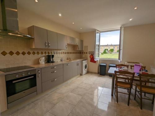 eine Küche mit Küchengeräten aus Edelstahl und einem Esstisch in der Unterkunft Gîte charmant au cœur d'un château historique avec parc, proche de Cognac, idéal famille et nature - FR-1-653-167 in Cherves-de-Cognac