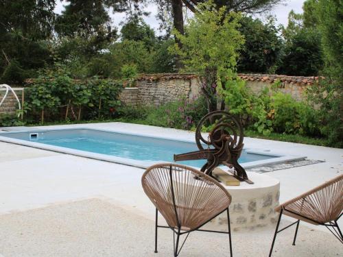 une statue assise sur une table à côté d'une piscine dans l'établissement Gîte à Fontclaireau : piscine privative, jardin clos, 4 ch., draps et linge fournis - FR-1-653-202, à Fontclaireau