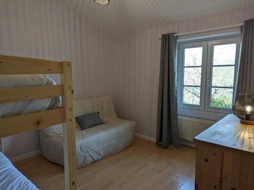 - une chambre avec des lits superposés, un canapé et une fenêtre dans l'établissement Gîte familial avec piscine chauffée et wifi, au cœur de la nature, proche Chadurie, Charente - FR-1-653-172, à Montmoreau
