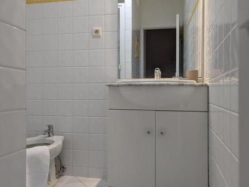 une salle de bain blanche avec un lavabo et un miroir dans l'établissement Gîte familial avec piscine chauffée et wifi, au cœur de la nature, proche Chadurie, Charente - FR-1-653-172, à Montmoreau