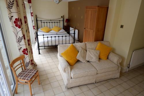 uma sala de estar com um sofá e uma cama em Colchester Sunny Studio Apartment with EV Charging Point em Lexden
