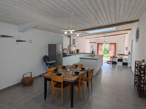 une cuisine et une salle à manger avec une table et des chaises dans l'établissement Maison en pierres rénovée avec jardin, terrasse, 3 chambres, proche village, nature paisible, équipements complets - FR-1-653-187, à Montboyer