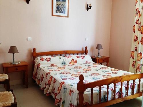 une chambre avec un lit avec un couvre-lit fleuri dans l'établissement Maison avec Jardin, Cheminée et Proche Activités, Idéale Famille - Animaux Acceptés - FR-1-653-198, à Champniers