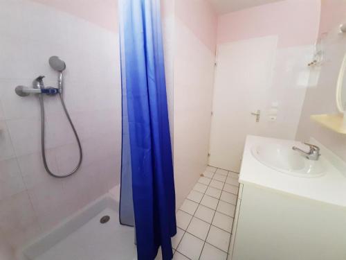 Baño con cortina de ducha azul junto a un lavabo en Gîte Champniers, 3 pièces, 4 personnes - FR-1-653-198, en Champniers