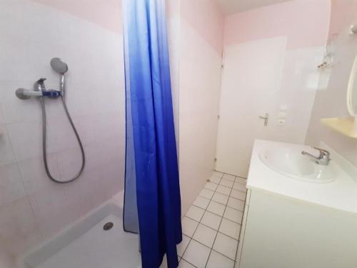 La salle de bains est pourvue d'un rideau de douche bleu à côté d'un lavabo. dans l'établissement Gîte Champniers, 3 pièces, 4 personnes - FR-1-653-198, à Champniers