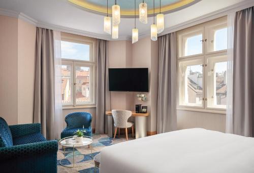 una camera d'albergo con letto, tavolo e sedie di Allure Hotel Prague a Praga